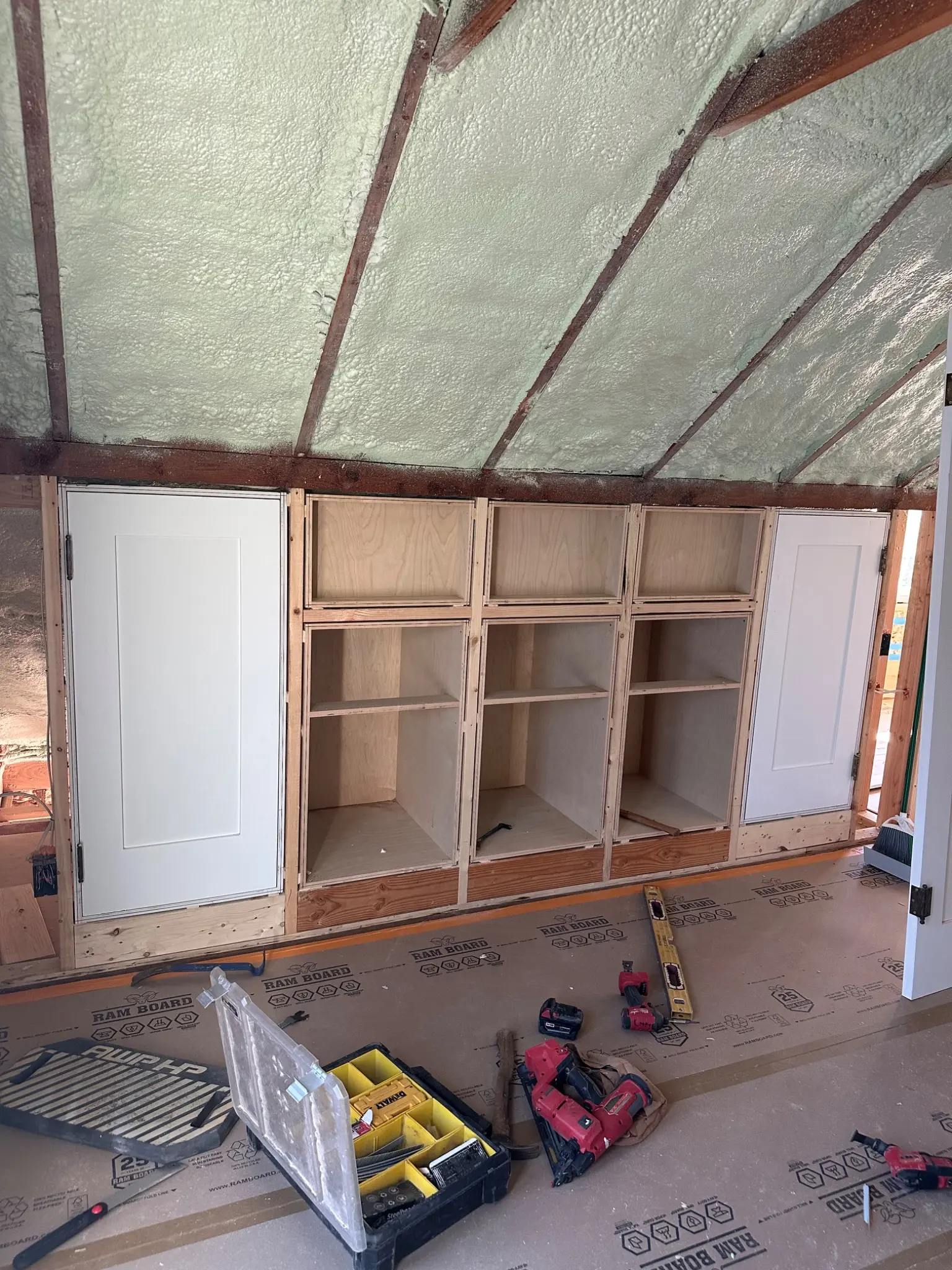 Built-in storage taking shape beneath the sloped roof