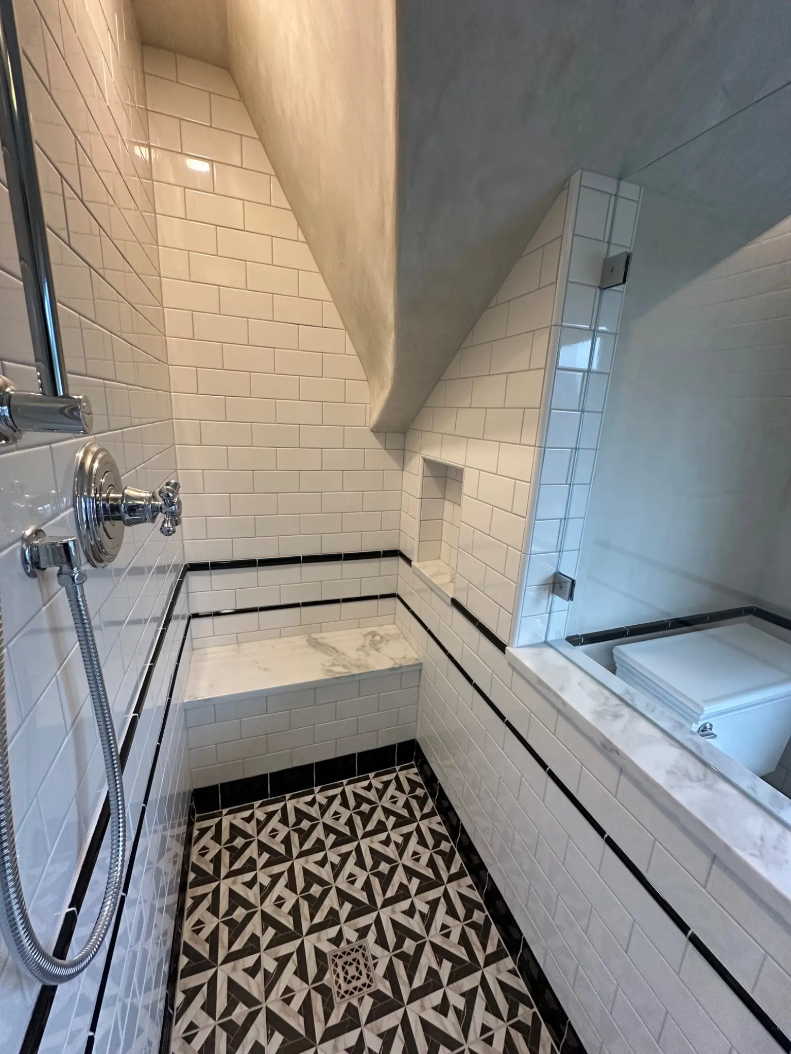 Tiled shower beneath the sloping roof
