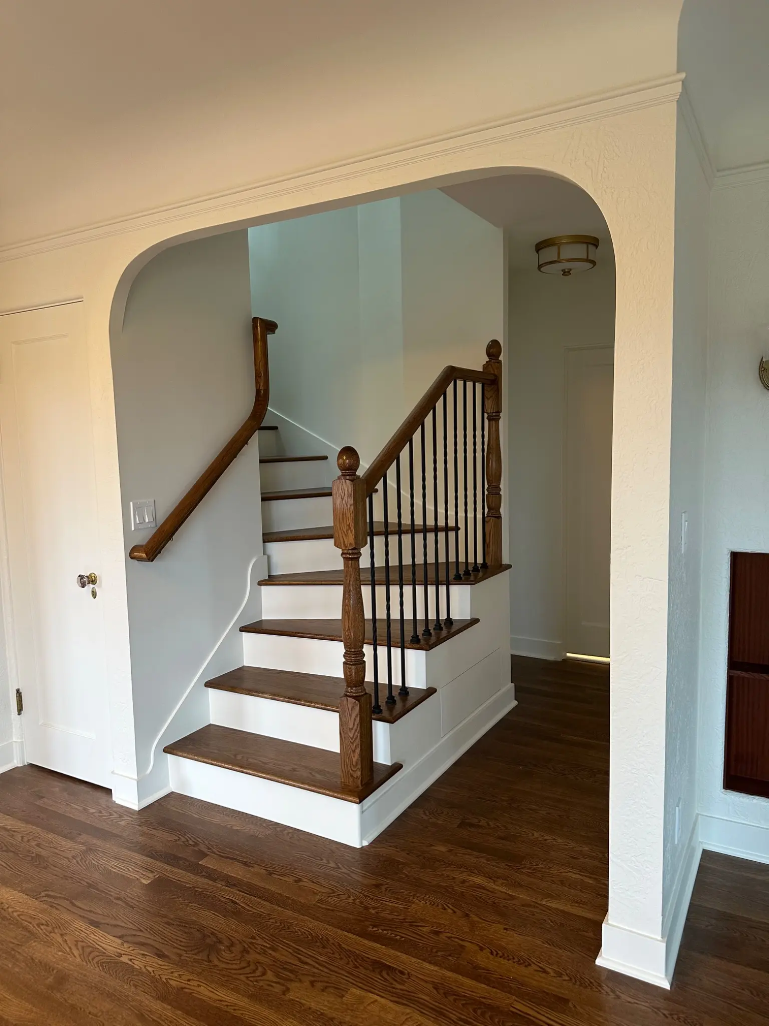 Completed winder staircase framed by a plaster arch
