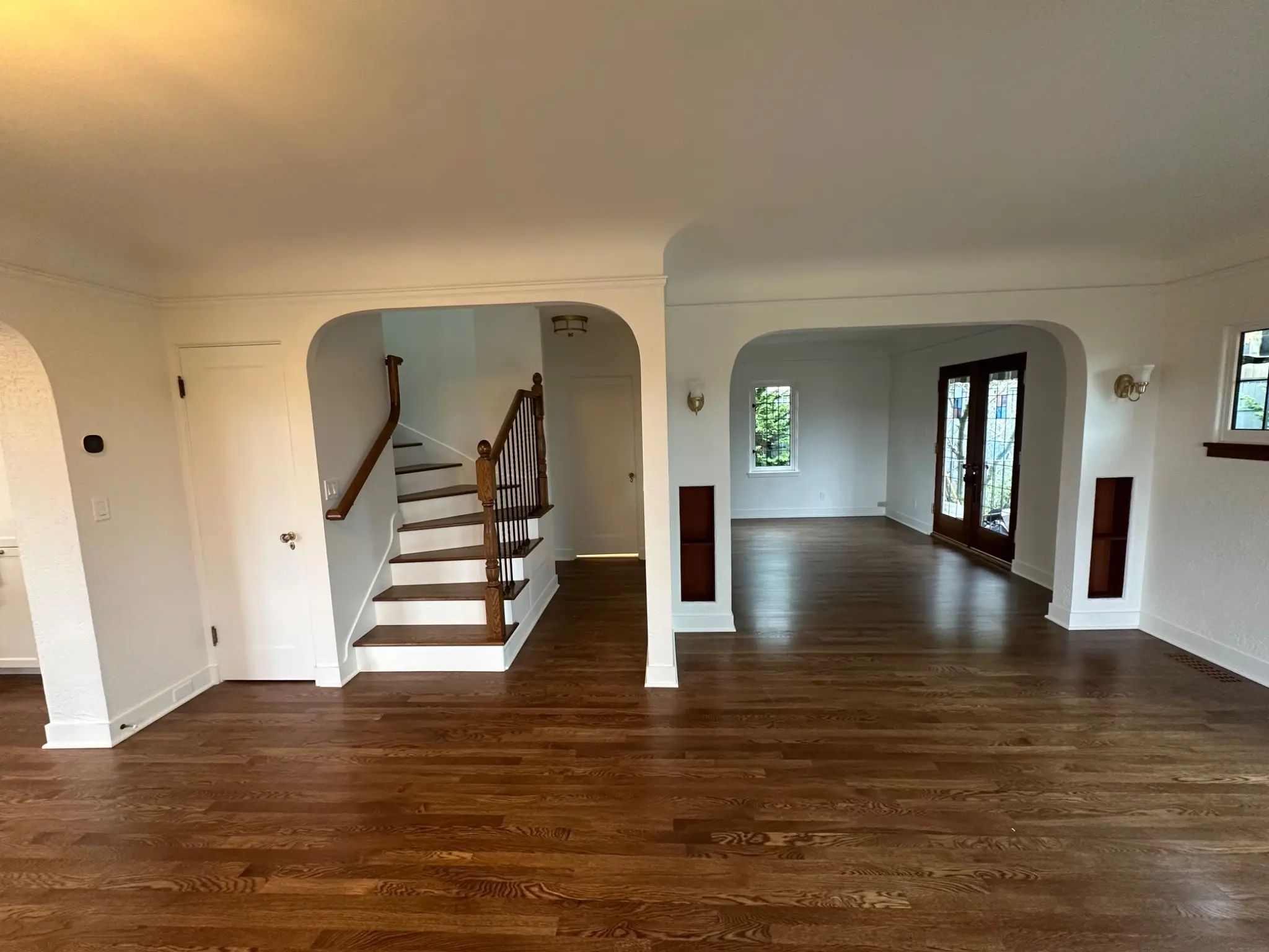Completed living room, plaster arches, and winder staircase