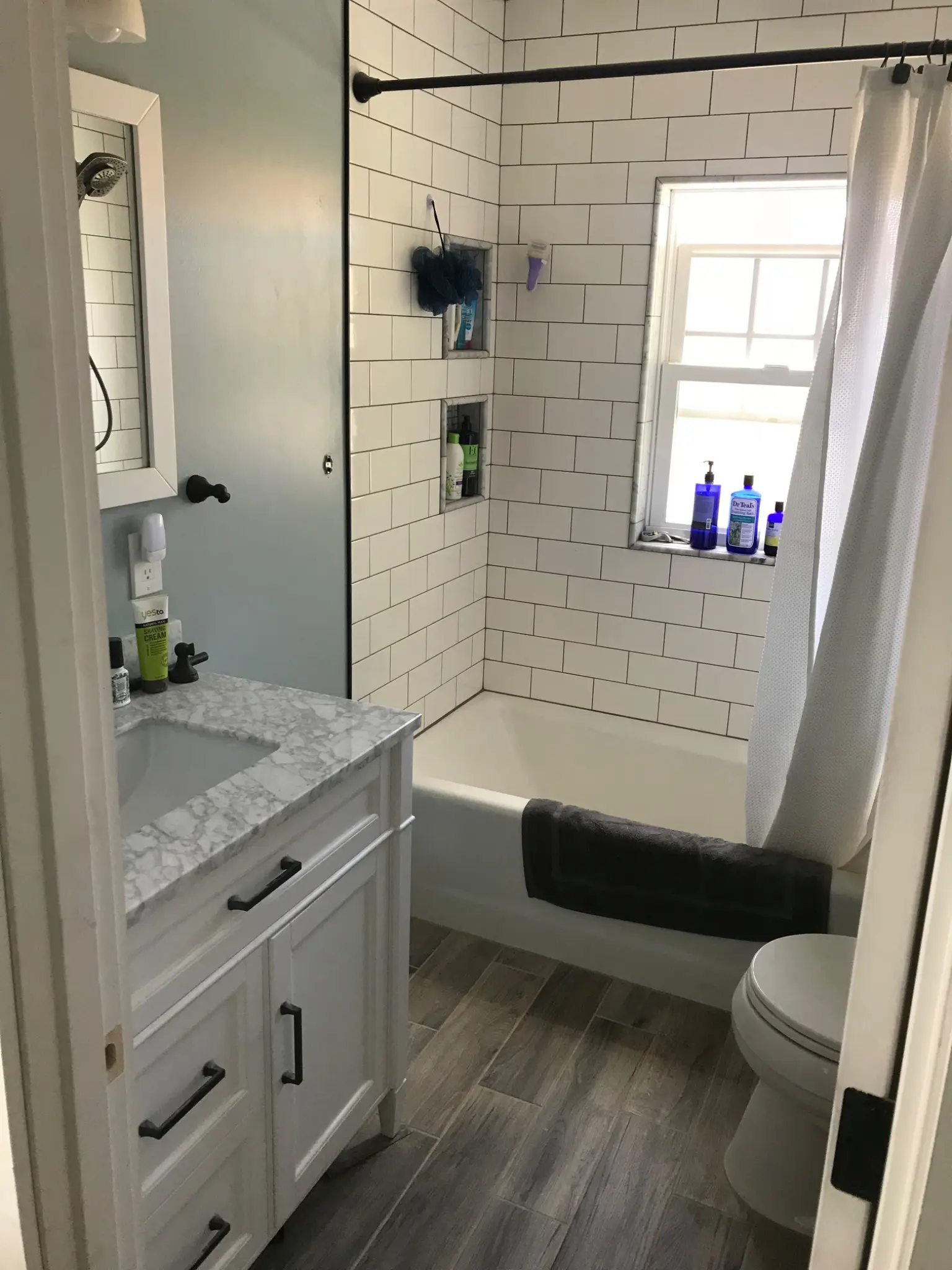 Completed bathroom with tiled tub surround