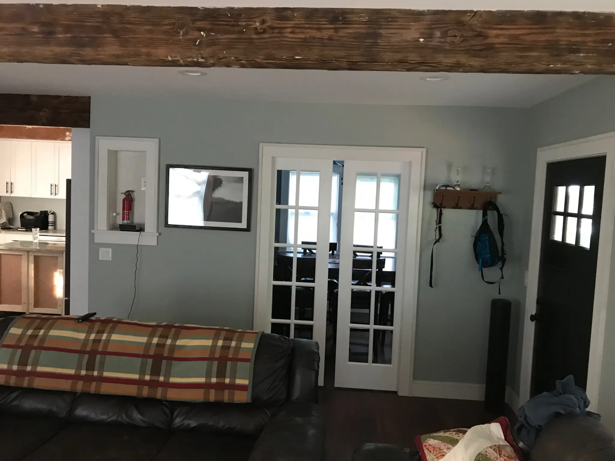 Completed living area with exposed beam and French doors